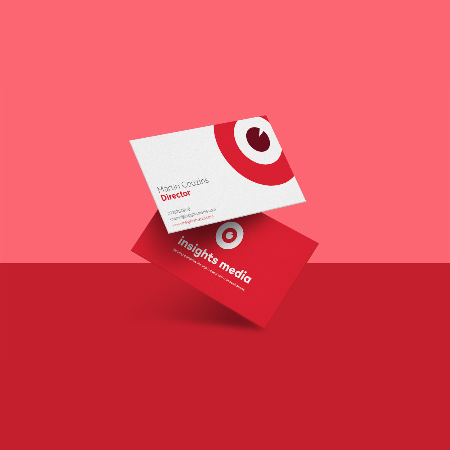 Insights Media business cards — red and white double-sided cards floating on coral background with bold circular logo