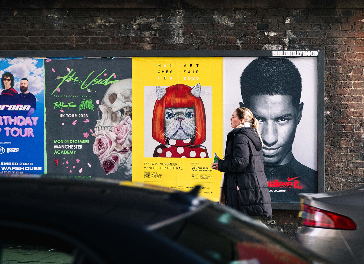 Manchester Art Fair 2023 — street-level poster hoardings on Albion Street featuring illustrated and photographic artwork